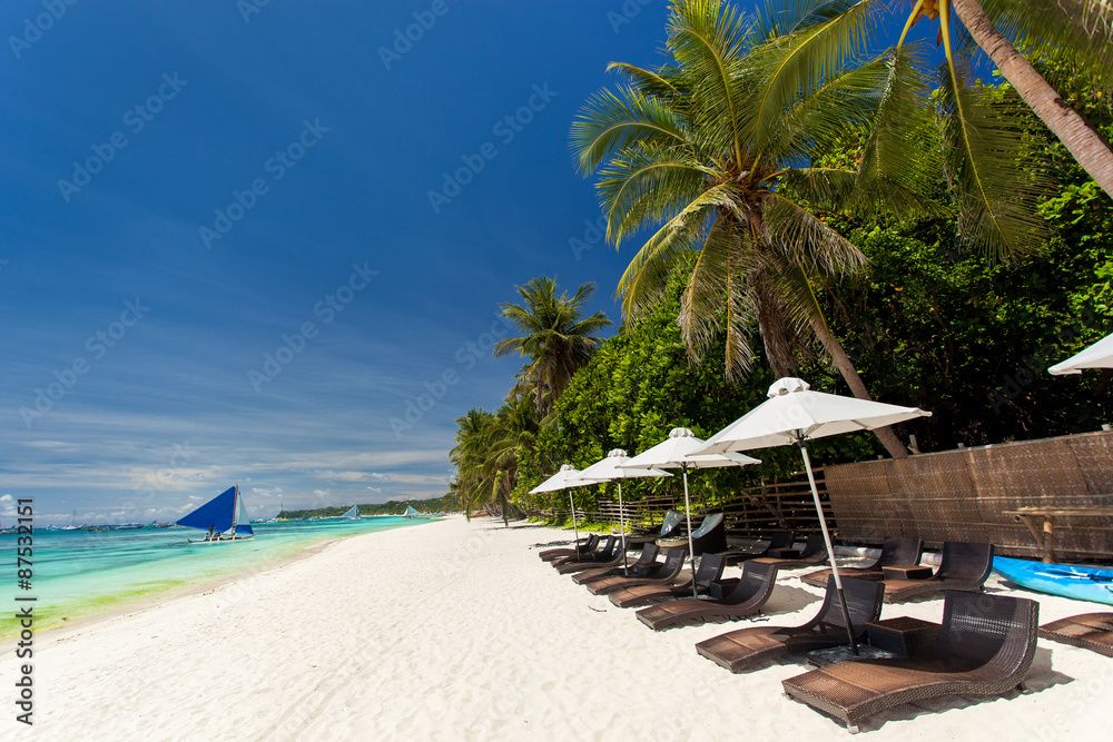 热带海岸线上的遮阳伞和沙滩椅