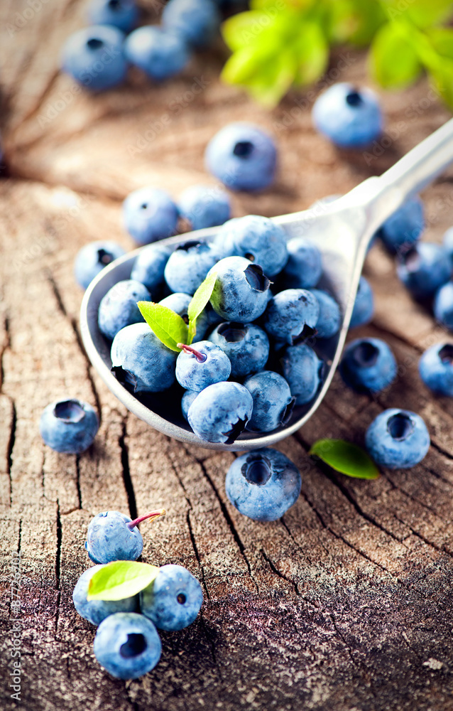 木质背景上的蓝莓。成熟多汁的新鲜采摘蓝莓特写