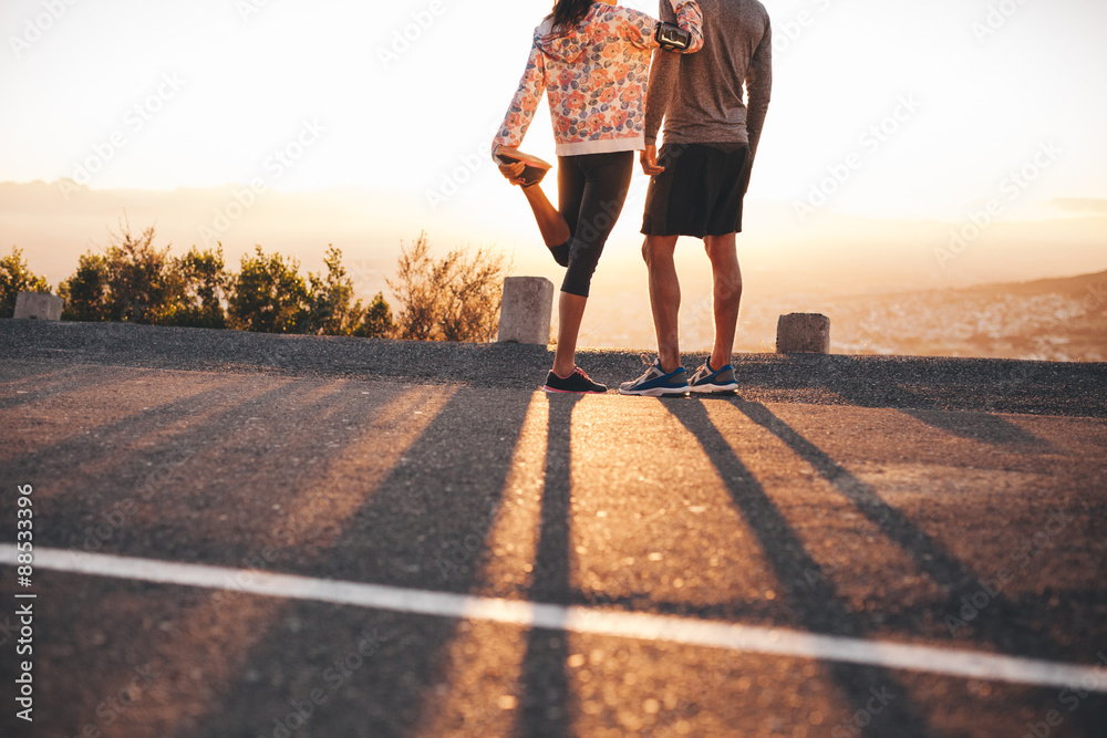 Couple of joggers looking at sunrise