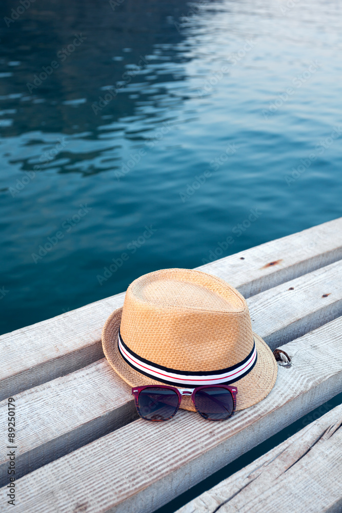 Sunglasses and hat on the wooden texture in summer