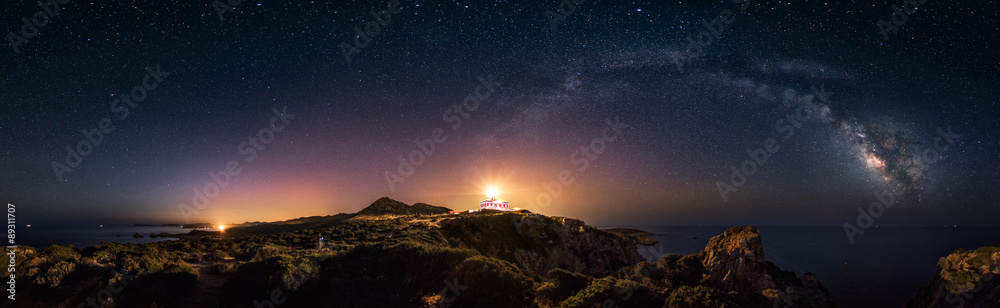 360° rectilinear panoramic view of starry night with milky way arc and lighthouse of Capo Spartivent