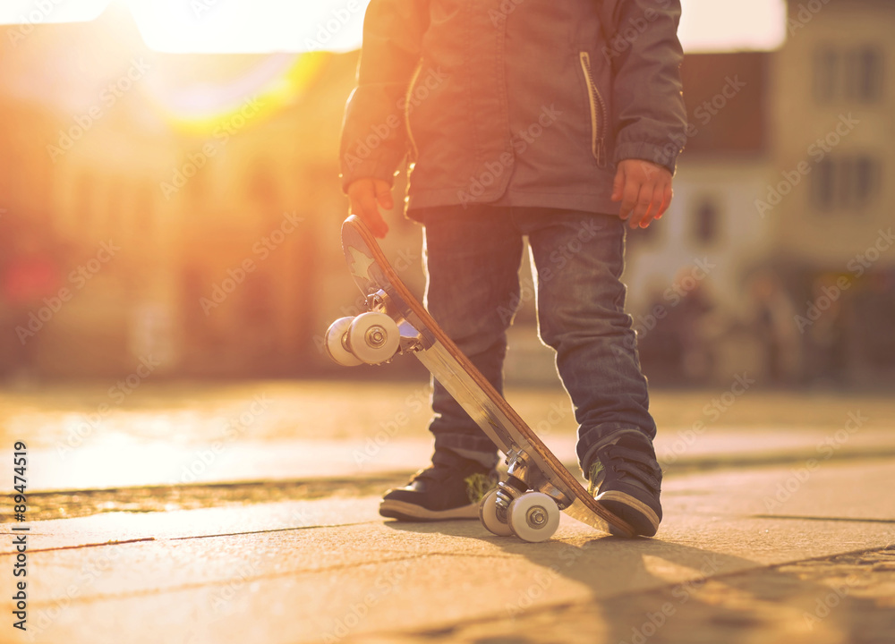 日落时分，孩子在街上玩滑板。