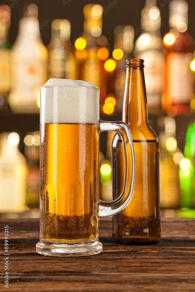 Glass of light beer with bar on background