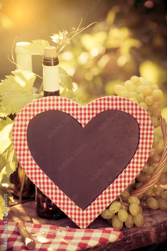 Wooden blackboard blank, wine bottle and grapes of vine
