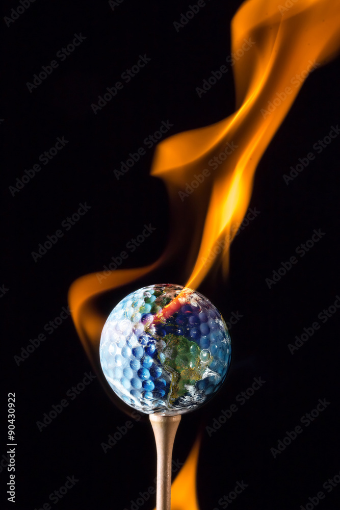 地球粘在黑色背景上有火焰的高尔夫球上。这张图片的元素提供了b