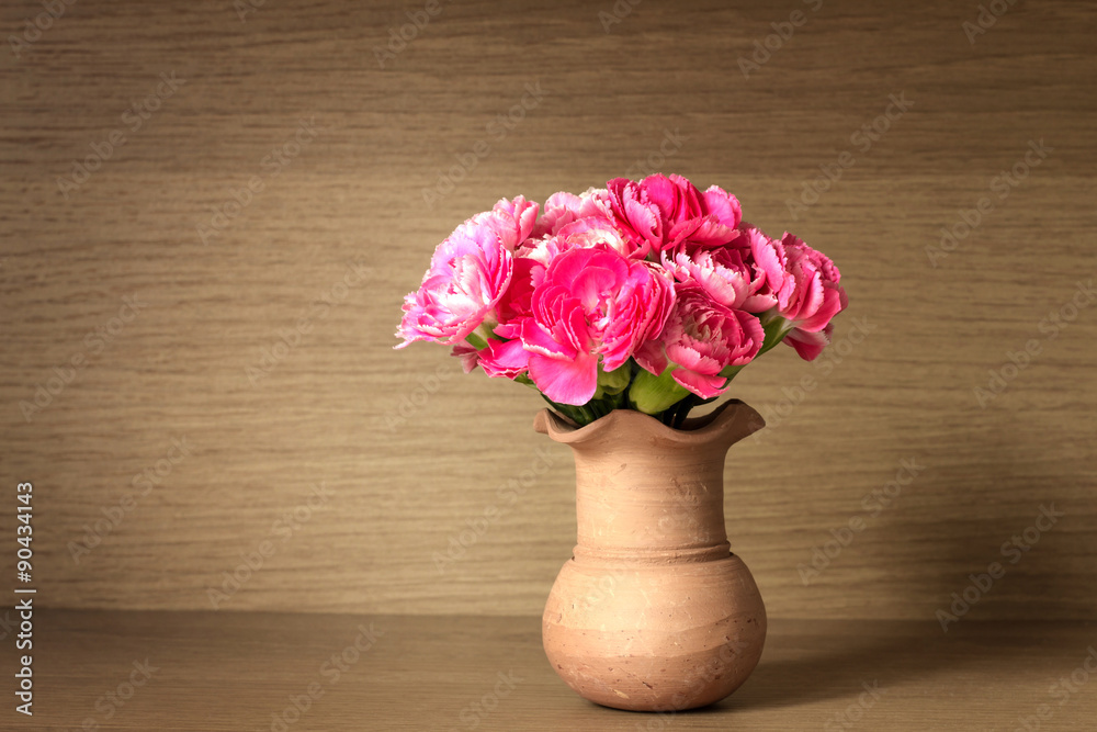 木架子背景上的鲜粉色康乃馨花