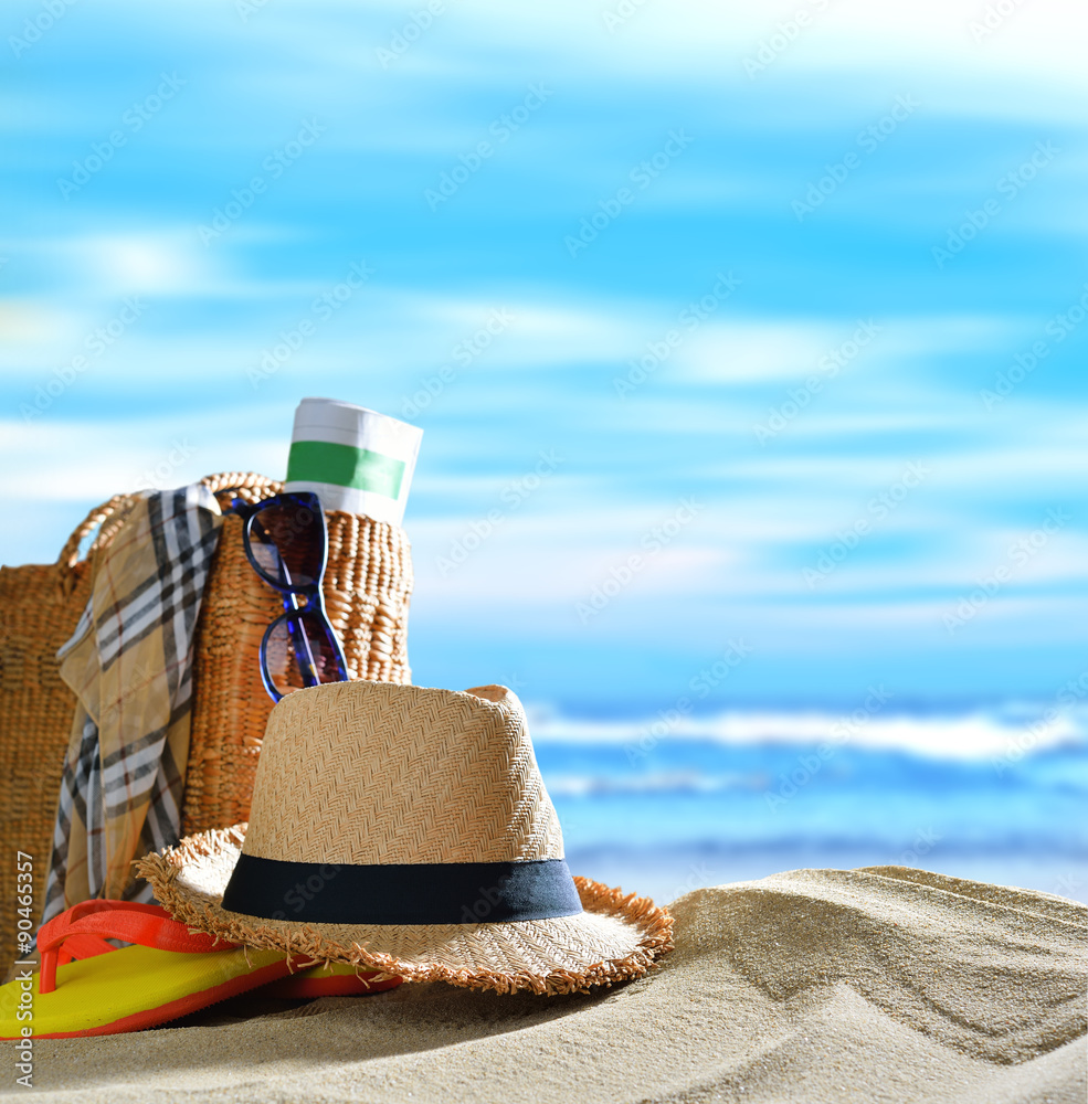 Beach accessories on sandy beach with blue sea and sky background