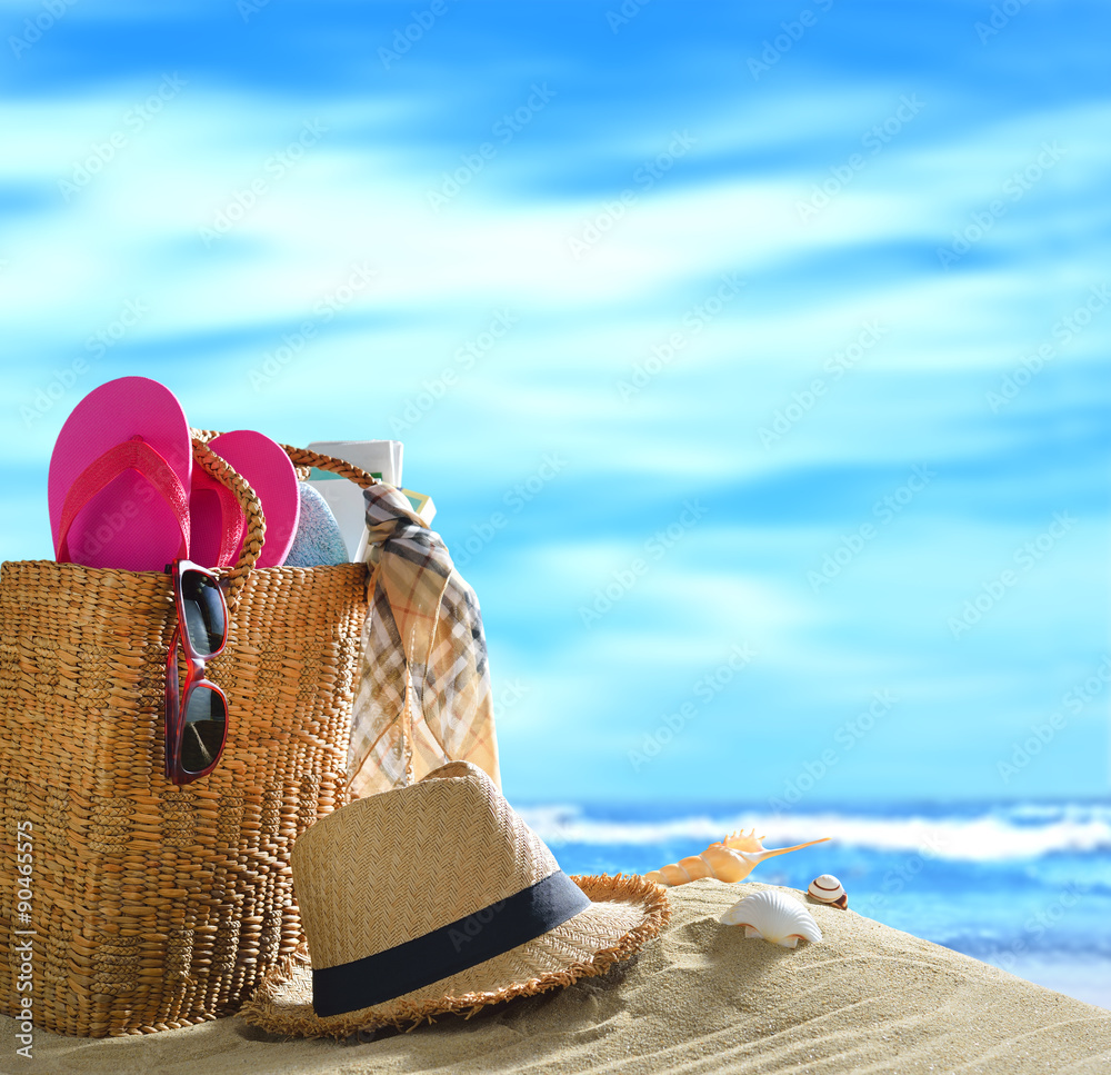 Beach accessories on sandy beach with blue sea and sky background