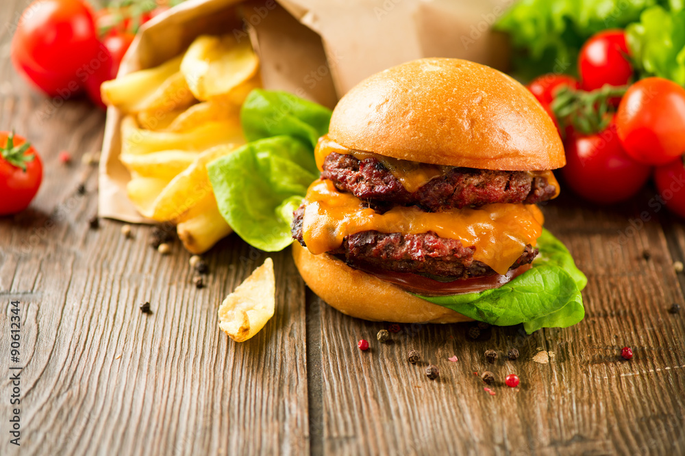 Hamburger with fries on wooden table