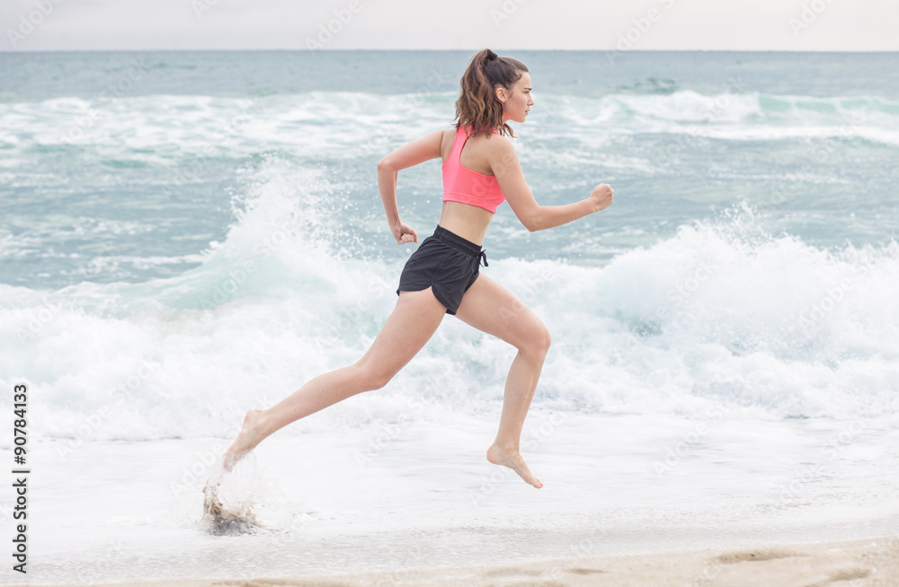 魅力四射的运动型女性在海滩上奔跑