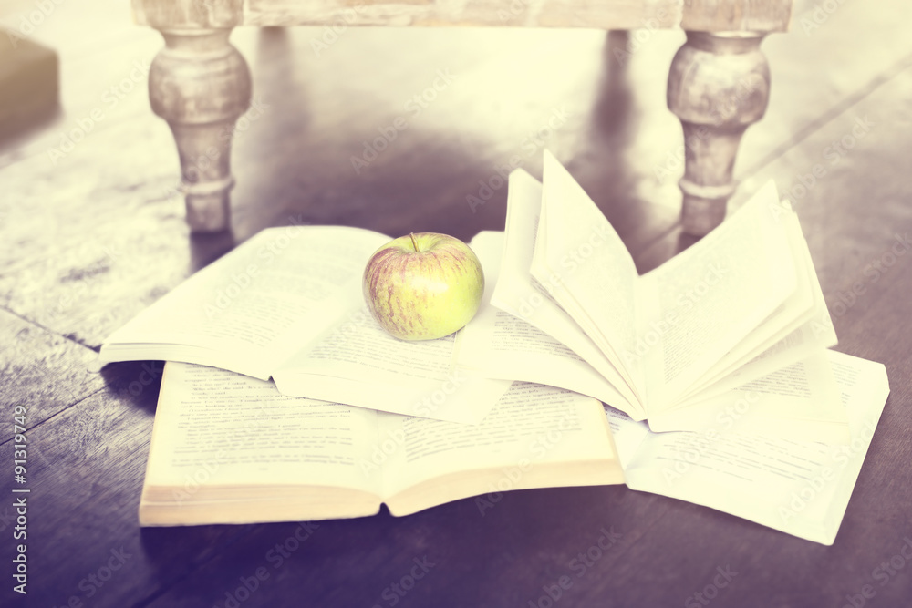 一些书和地板上的一个苹果