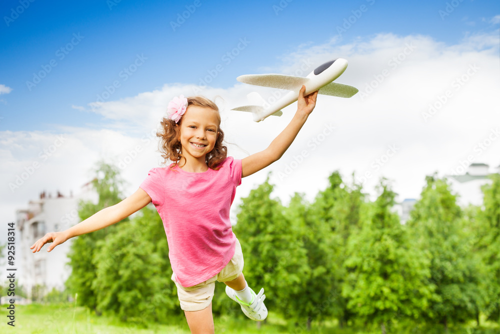 女孩单腿抱着飞机玩具