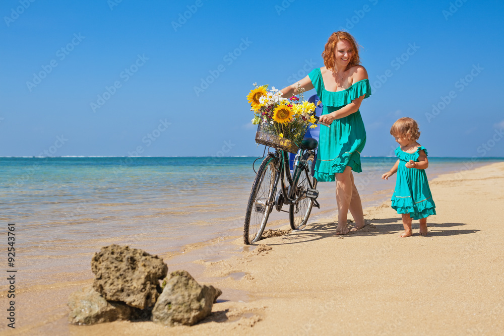幸福的家庭-小女孩和年轻的母亲在自行车运动后骑着自行车散步，玩得很开心