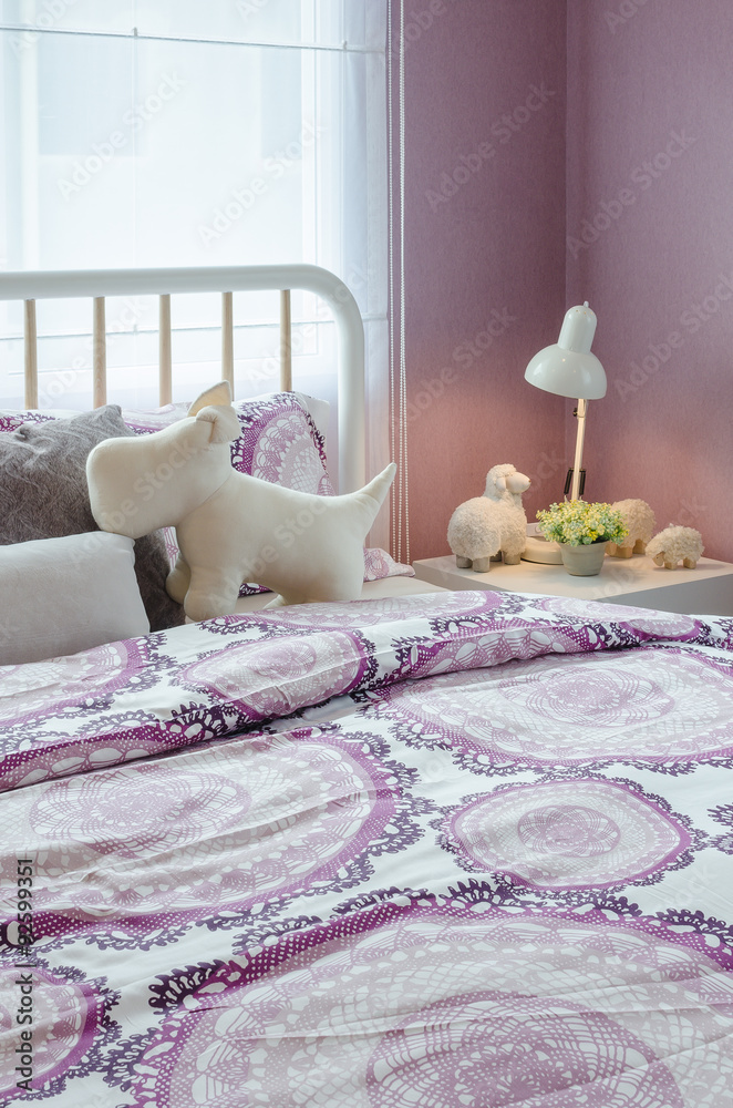 白色木床配紫色毯子和玩偶