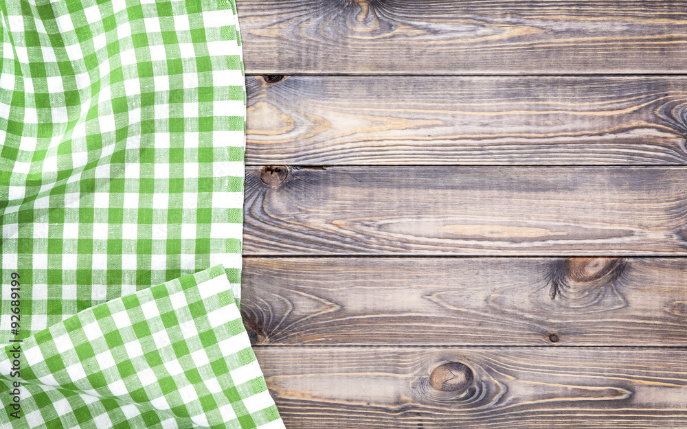 漂白木桌上的绿色折叠桌布