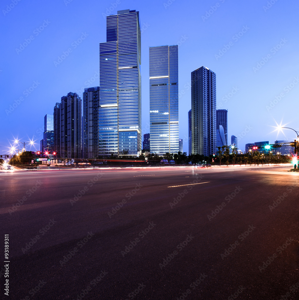 asphalt road near skyscrapers at night
