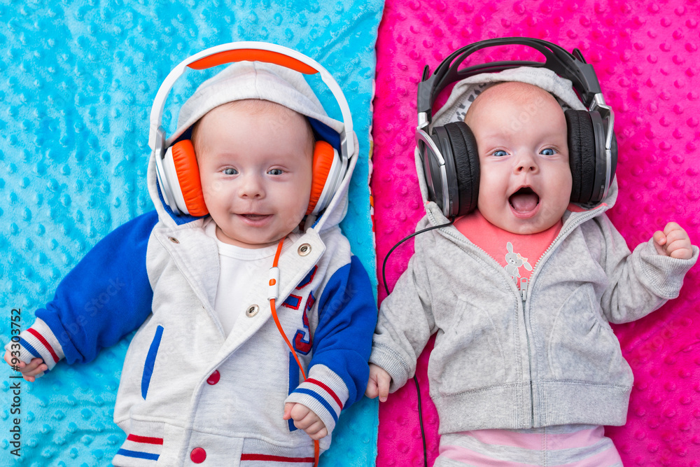 快乐的双胞胎宝宝用耳机听音乐