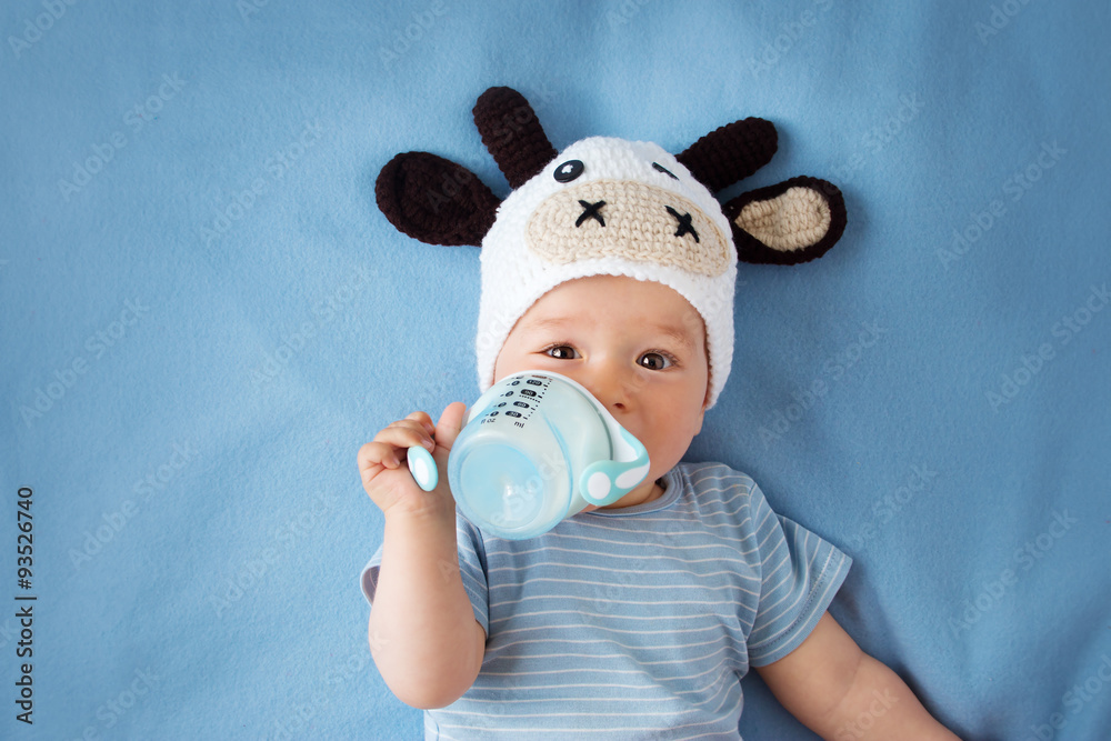 戴着奶牛帽的婴儿在喝牛奶