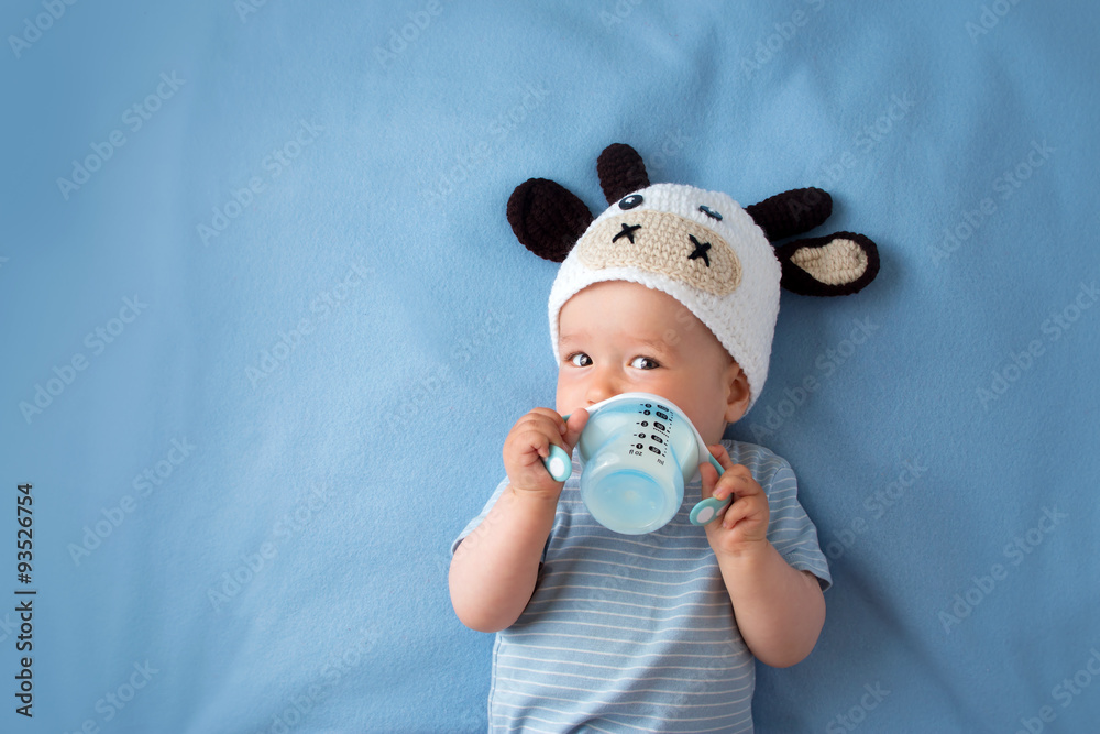Baby in a cow hat drinking milk