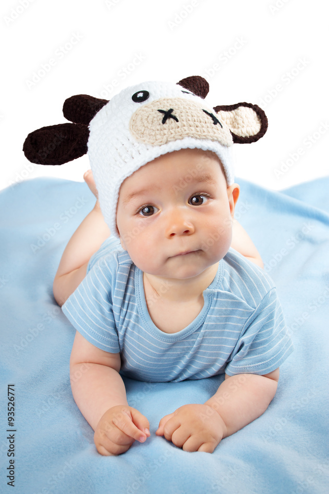 蓝色毯子上戴着奶牛帽的婴儿