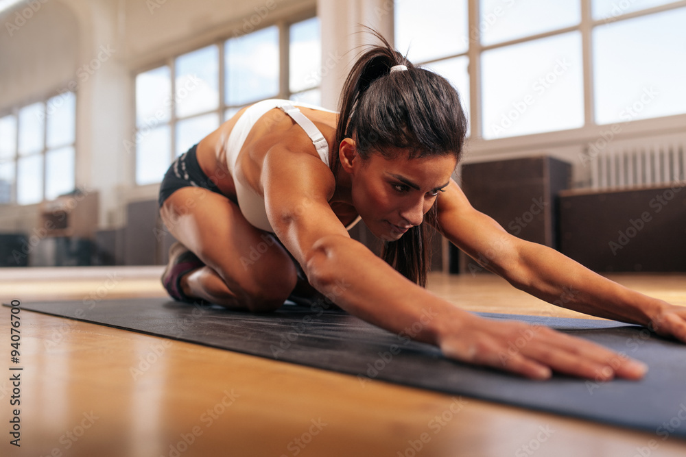 肌肉发达的女人在健身房做伸展运动