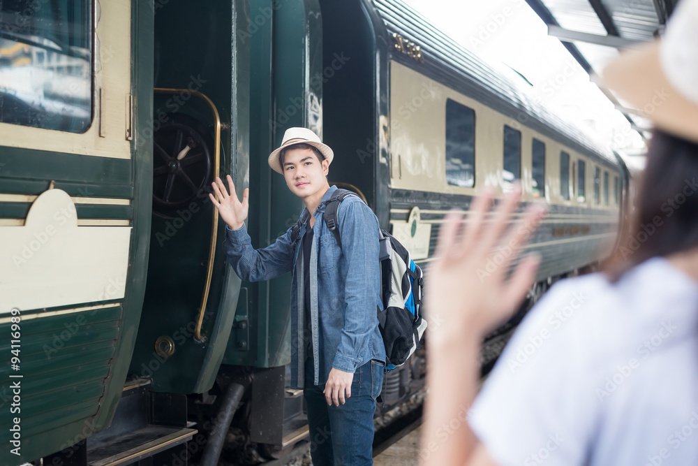 英俊的亚洲年轻男子在火车站向女友道别