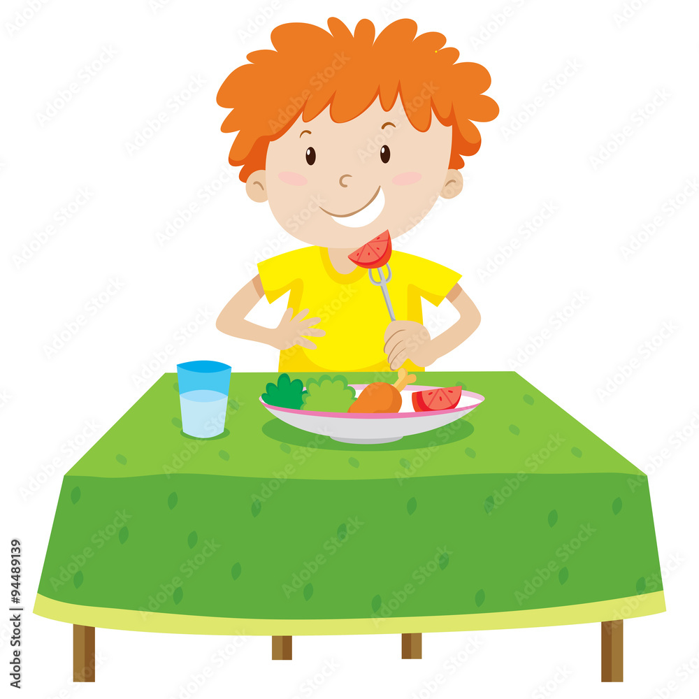 小男孩在桌子上吃饭