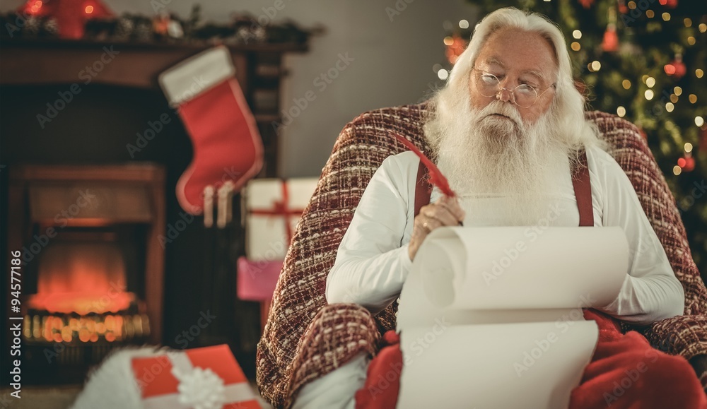 轻松的圣诞老人用羽毛笔写清单