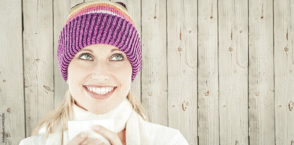 Composite image of smiling woman with a colorful hat and a cup