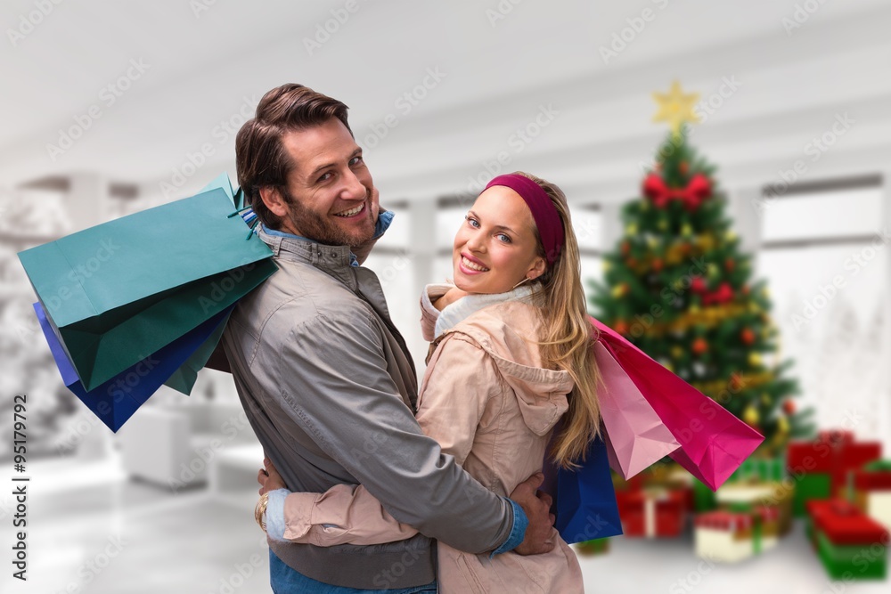 微笑的情侣拿着购物袋拥抱的合成图
