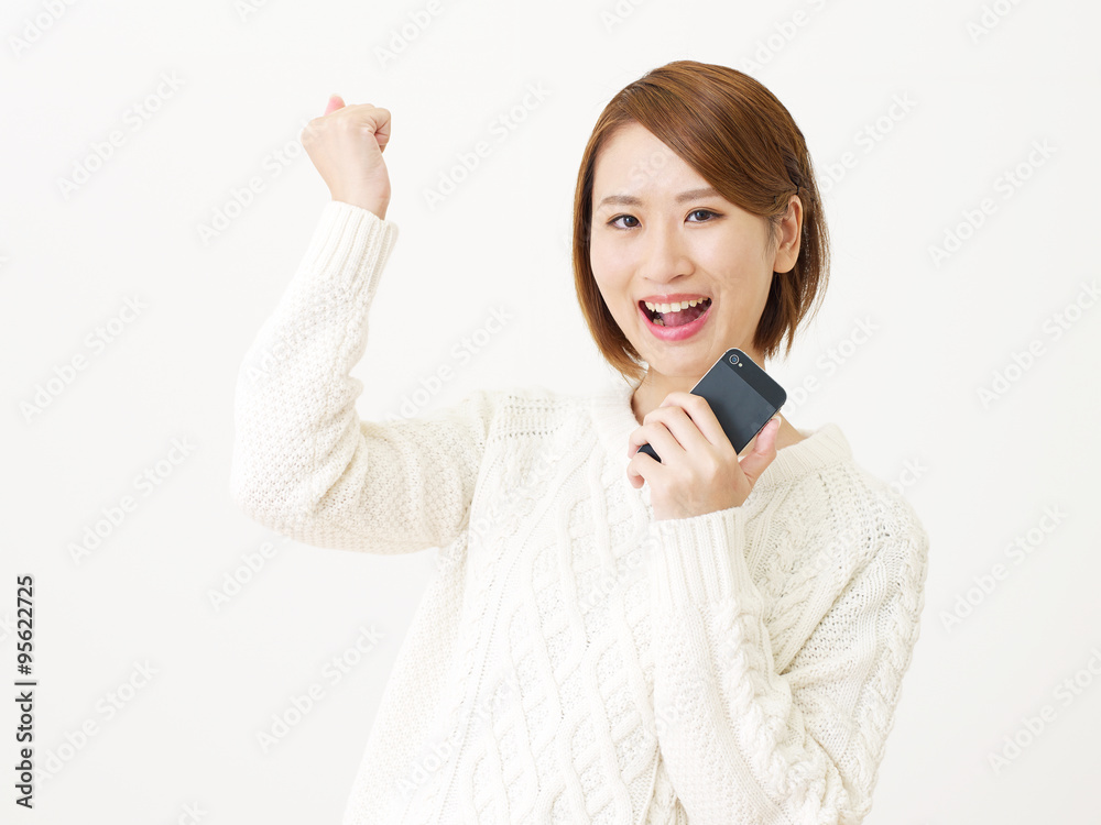 スマートフォンを持つ女性　ガッツポーズ