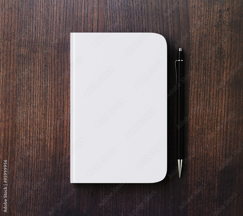 棕色木桌上的空白白色日记封面和钢笔，实物模型