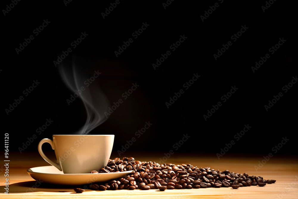 一杯咖啡，烟雾和咖啡豆放在旧木质背景上