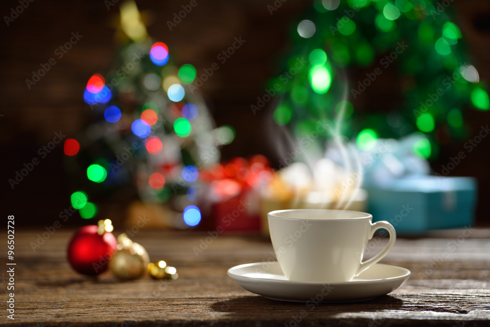 一杯带有烟雾的咖啡，周围是圣诞灯背景上的圣诞装饰
