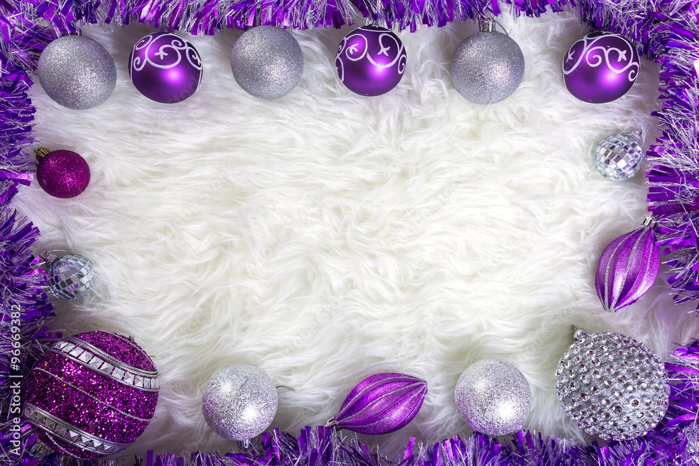 框架由蓬松地毯上的紫色和银色圣诞饰品制成