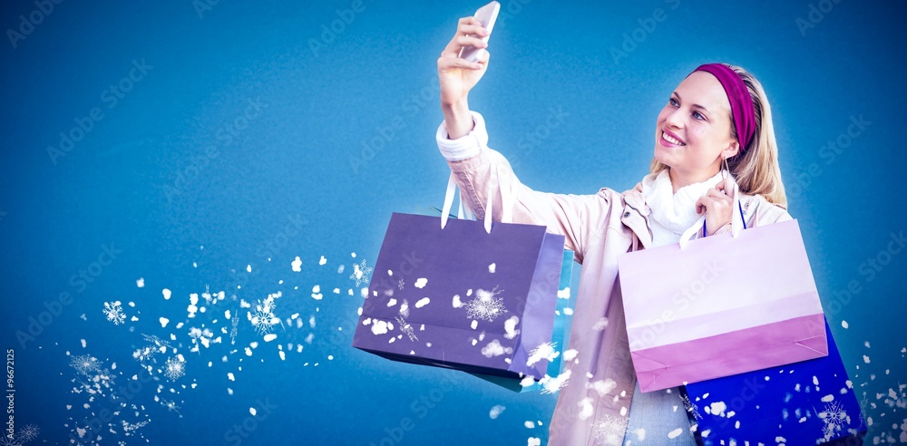 Smiling woman with shopping bags taking selfie