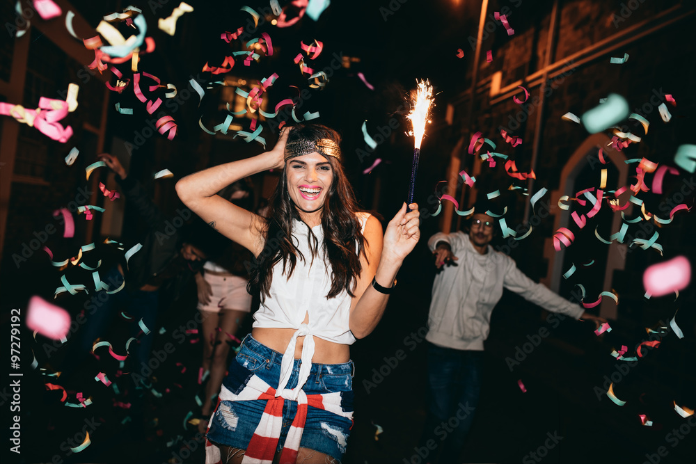 Friends partying outdoors with confetti and sparklers