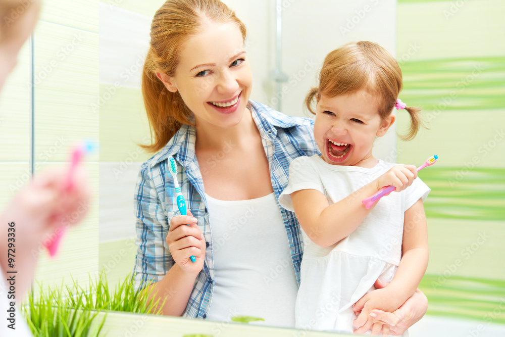 快乐家庭妈妈和女孩用牙刷刷牙