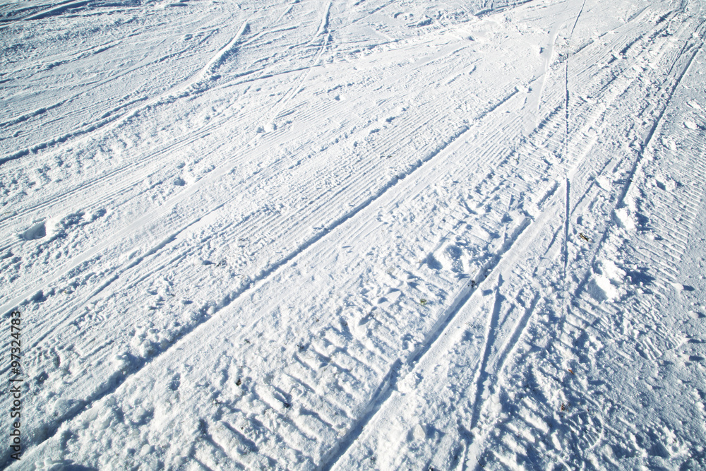 阳光明媚的雪道滑雪道与滑雪道的特写。抽象的冬季滑雪道细节背景