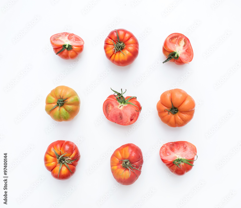  Selection of heirloom tomatoes on a white backdrop.