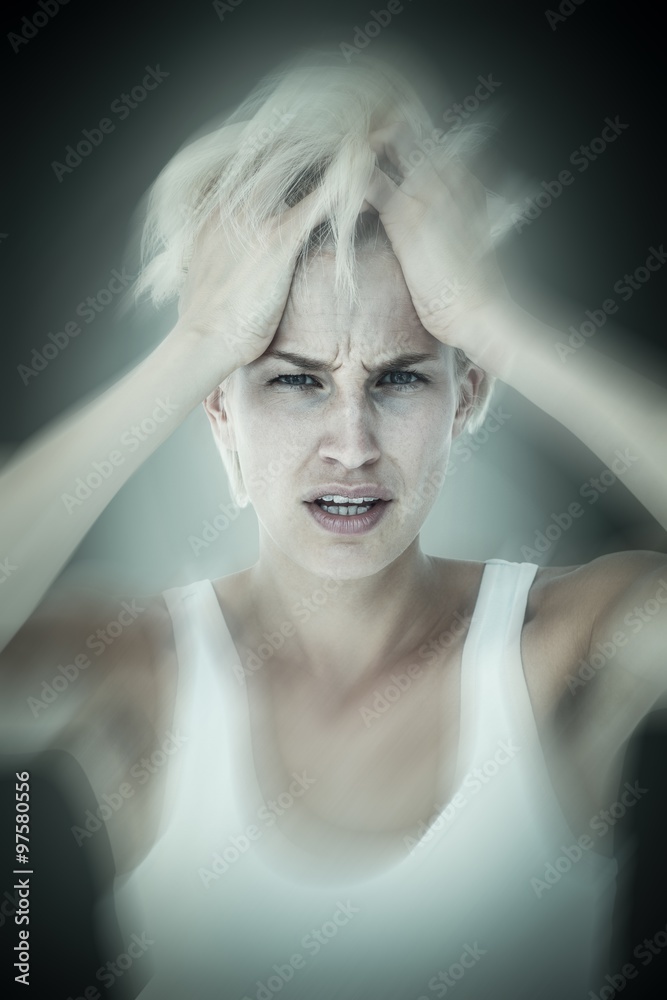 Sad blonde woman with hands on hair