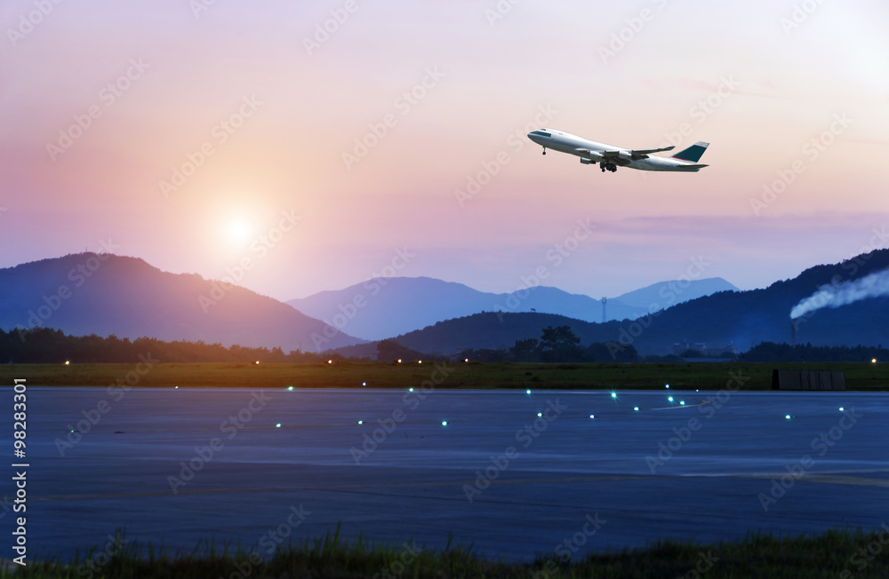 日落时分，客机从机场起飞，飞越跑道