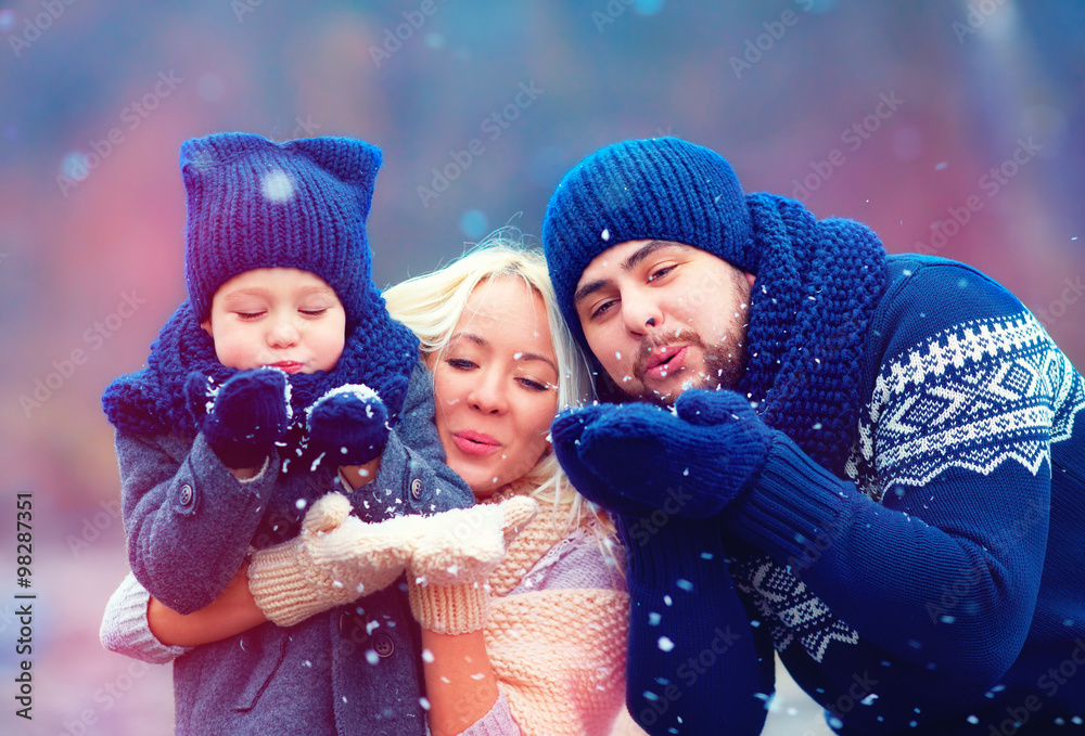 幸福家庭在户外吹冬雪的肖像