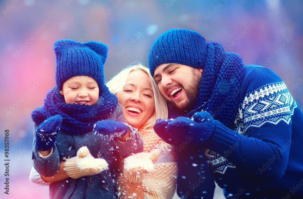 快乐家庭在户外吹冬雪的肖像，假日季节