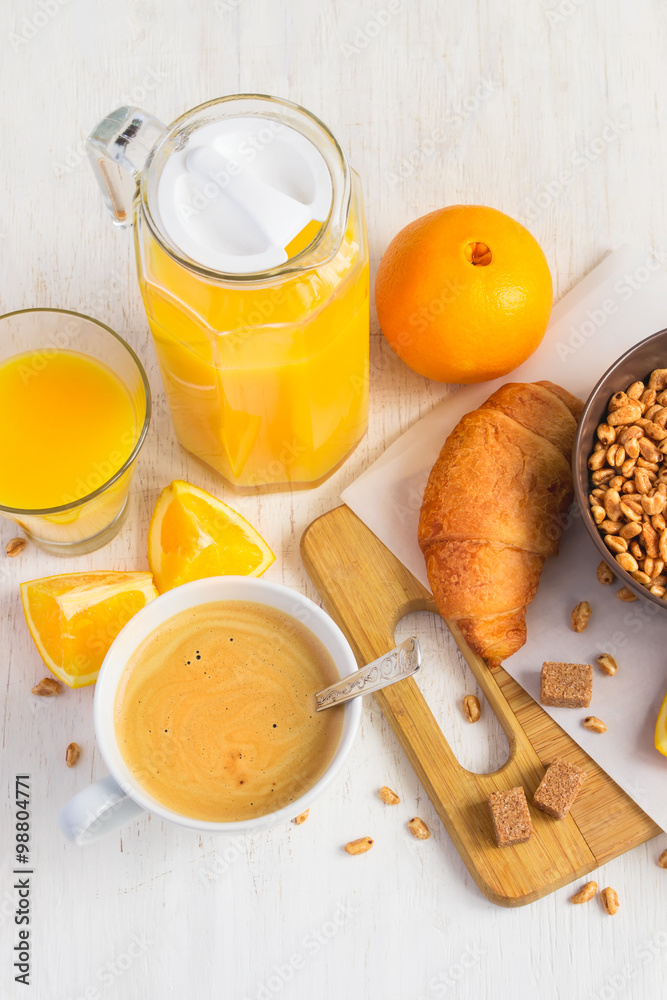 Breakfast concept - orange juice, croissant and coffee on a whit
