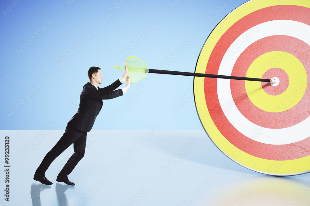 Move towards your goal concept with businessman pushing an arrow