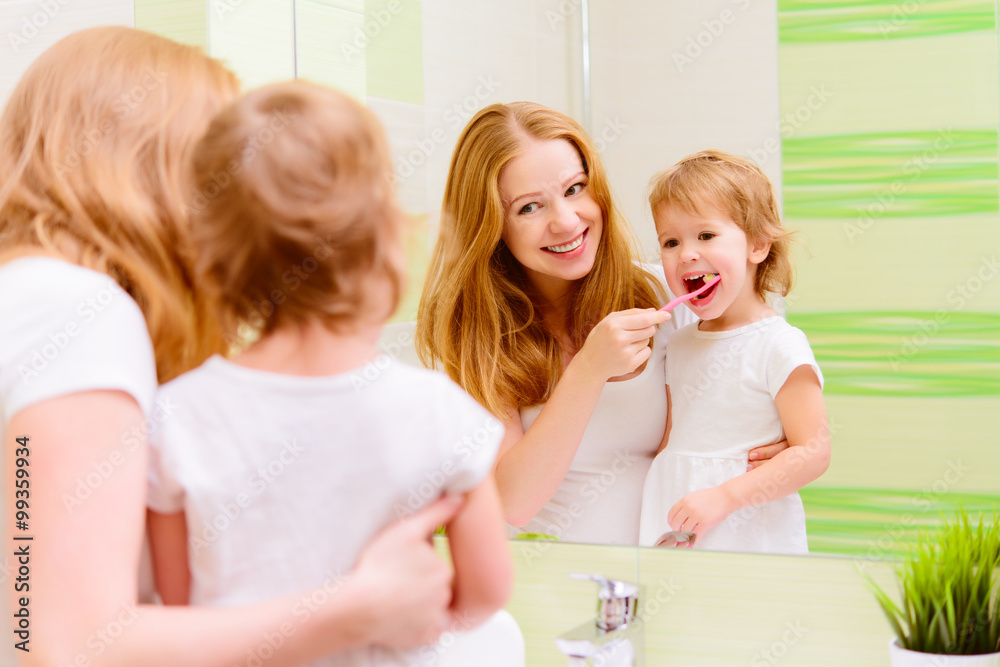 幸福的家庭母亲和女儿的孩子正在刷牙