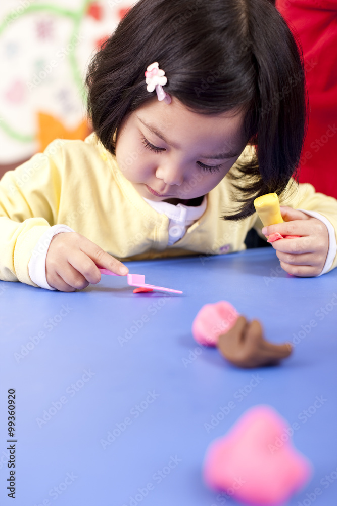Kindergarten teachers and children playing with childs play clay