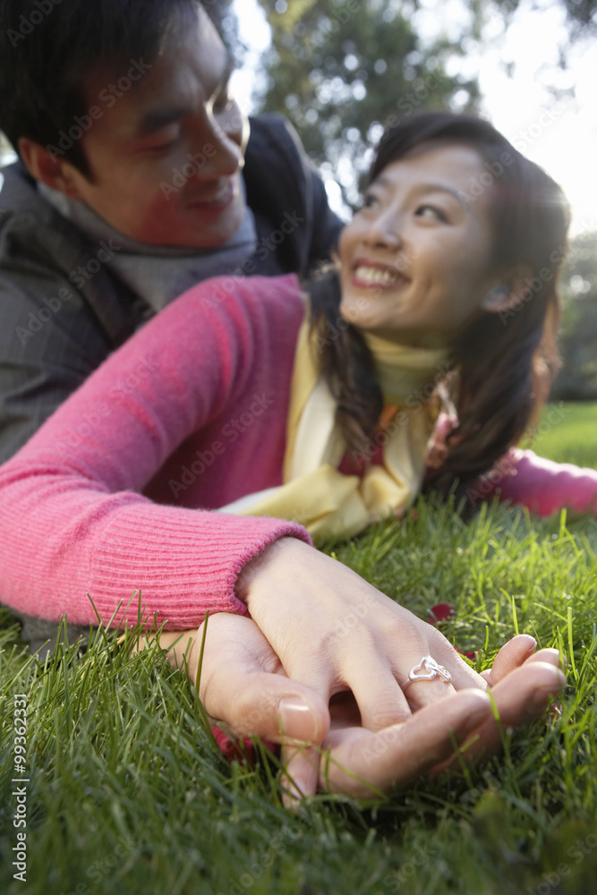 情侣在草地上打滚，手牵着手