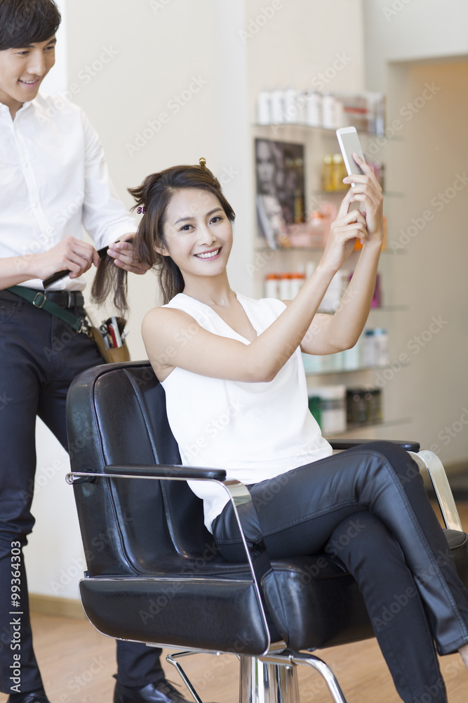 Female customer taking self portrait in barber shop